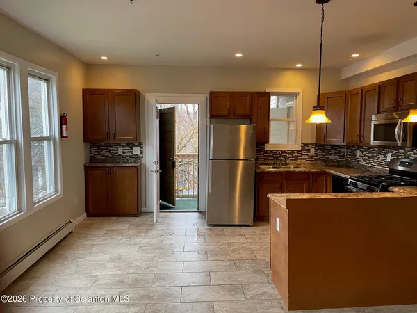 a kitchen with stainless steel appliances granite countertop a refrigerator a stove a sink and a refrigerator