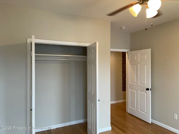 a view of an empty room with wooden floor