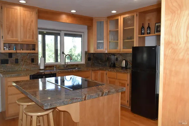 a kitchen with granite countertop a sink a stove and a wooden floor