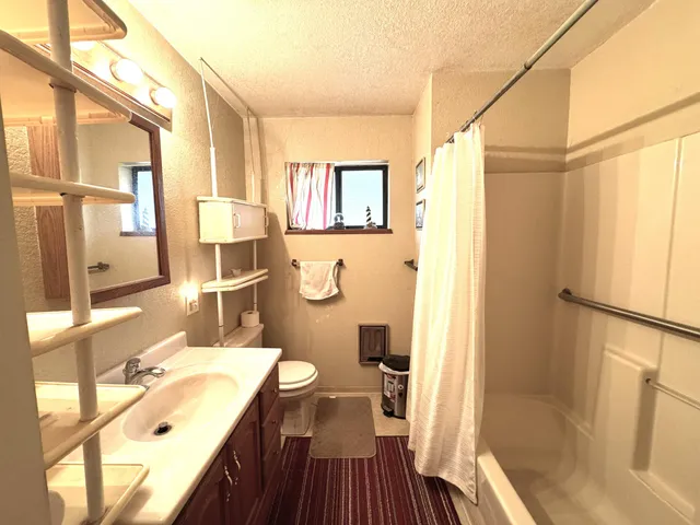 a bathroom with a tub a sink and a large mirror