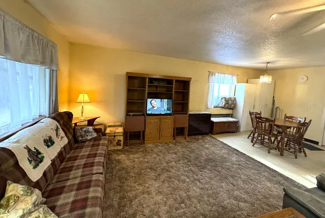 a living room with furniture and a dining table with kitchen view