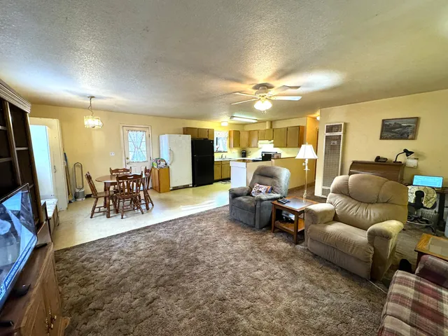 a living room with lots of furniture and kitchen view