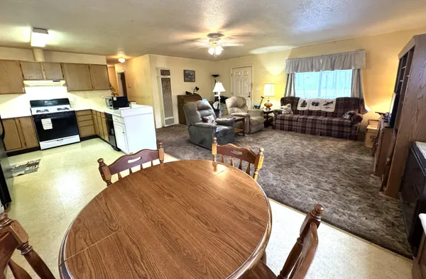 a dining room with furniture a chandelier and wooden floor