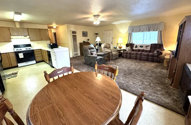 a dining room with furniture a chandelier and wooden floor