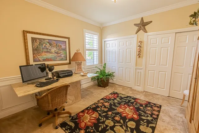 a view of a workspace with furniture and a window