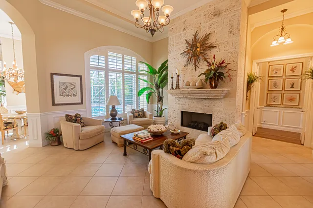 a living room with furniture a fireplace and a chandelier
