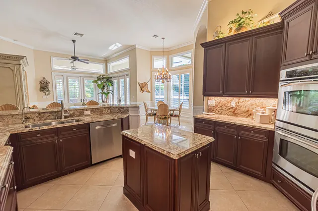 a kitchen with kitchen island granite countertop a sink stove and cabinets