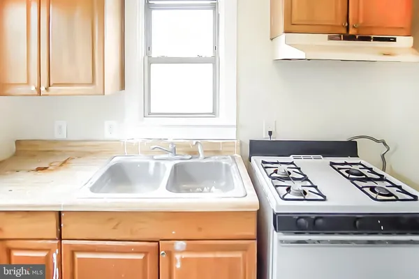 a kitchen with granite countertop a sink a stove and a microwave