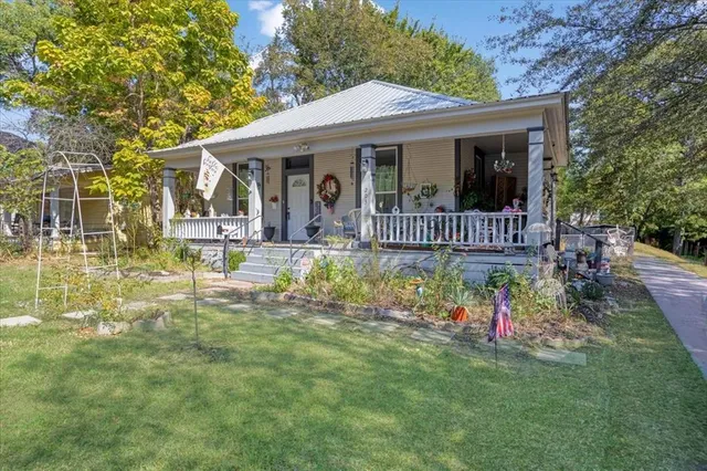 a view of a house with backyard and sitting area