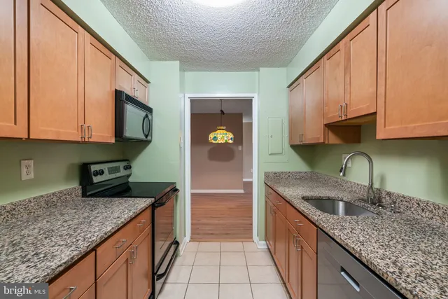 a kitchen with stainless steel appliances granite countertop a sink a stove and cabinets