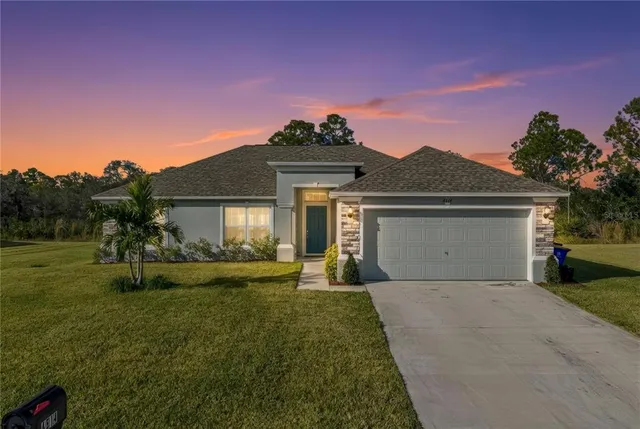 a front view of a house with a yard and garage