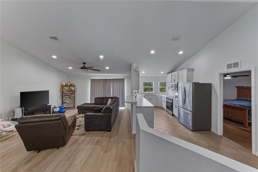 4514 Adrienne Street Sebring, FL 33872 - Photo 14 of 55 a living room with furniture a flat screen tv and a refrigerator
