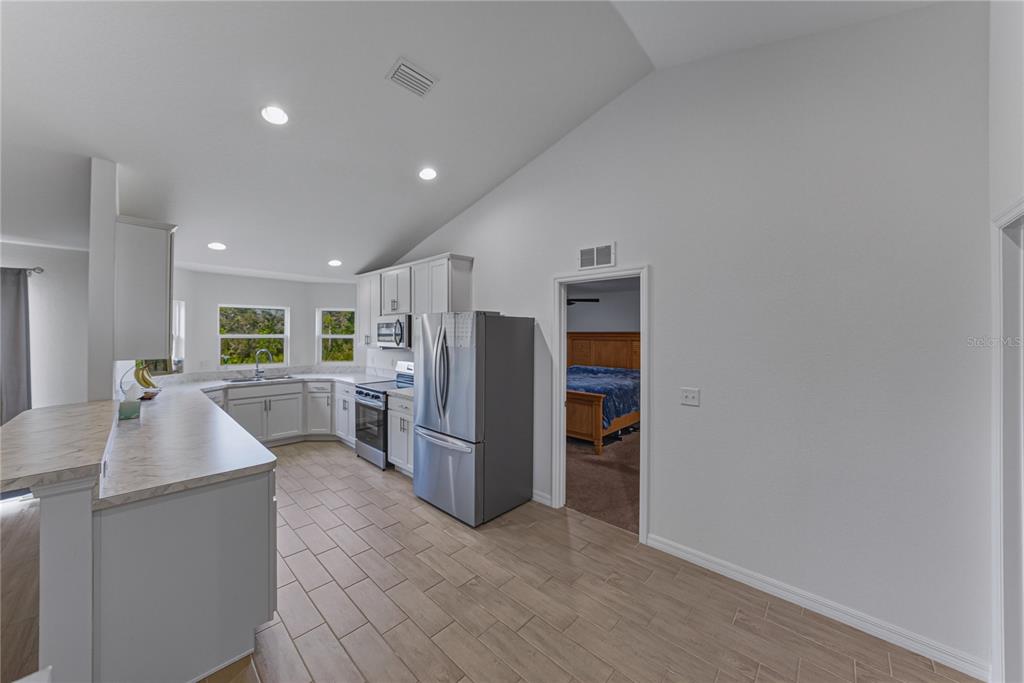 4514 Adrienne Street Sebring, FL 33872 - Photo 23 of 55 a kitchen with refrigerator and cabinets