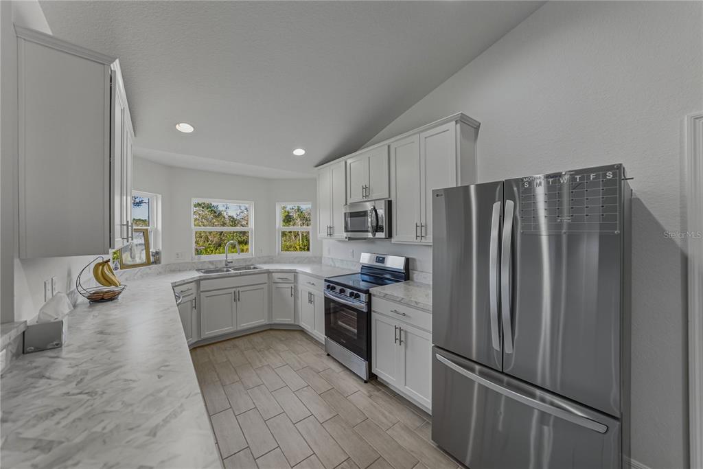 4514 Adrienne Street Sebring, FL 33872 - Photo 24 of 55 a kitchen with a refrigerator and a sink