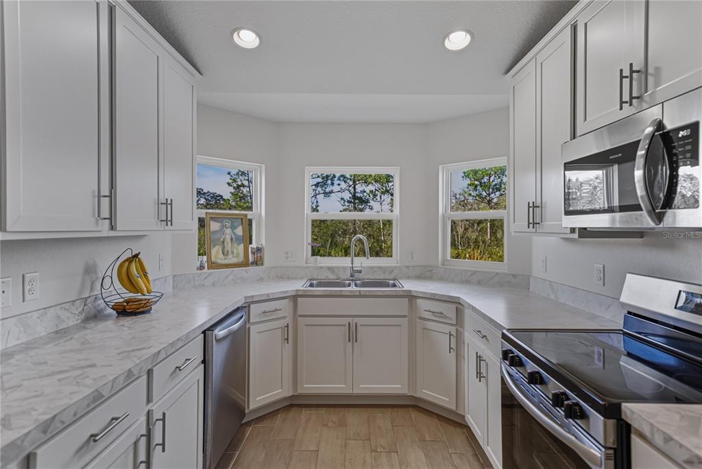 4514 Adrienne Street Sebring, FL 33872 - Photo 25 of 55 a kitchen with a sink stove and cabinets