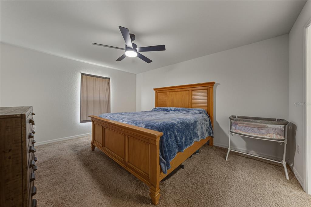 4514 Adrienne Street Sebring, FL 33872 - Photo 31 of 55 a bedroom with a bed and a chandelier