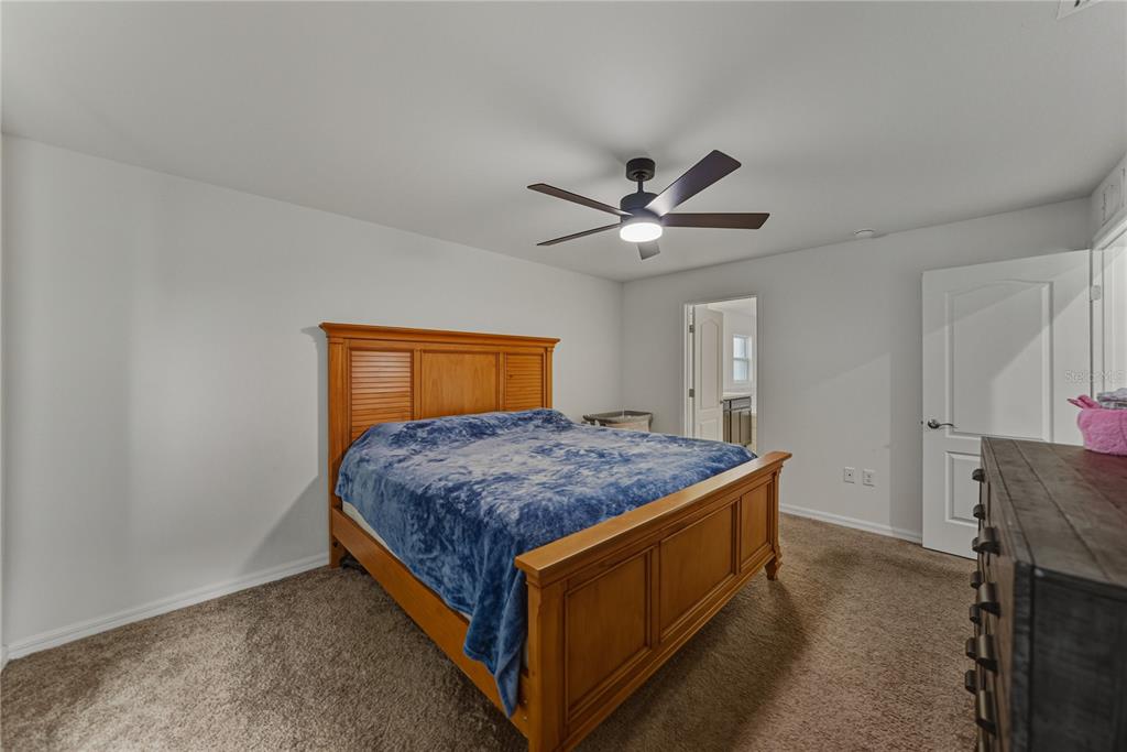 4514 Adrienne Street Sebring, FL 33872 - Photo 32 of 55 a bedroom with a bed and a chandelier