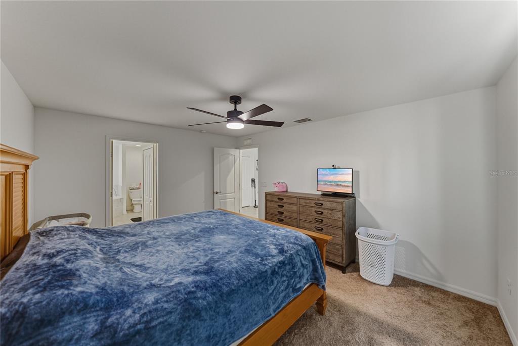 4514 Adrienne Street Sebring, FL 33872 - Photo 33 of 55 a bedroom with a large bed and a chandelier