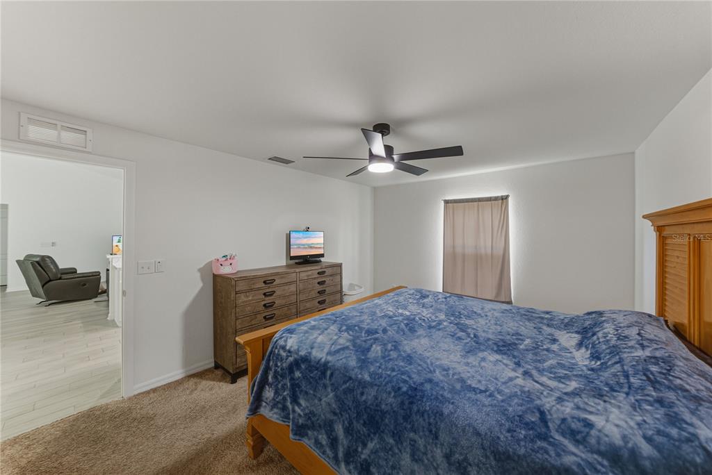 4514 Adrienne Street Sebring, FL 33872 - Photo 34 of 55 a bedroom with a bed and a chandelier