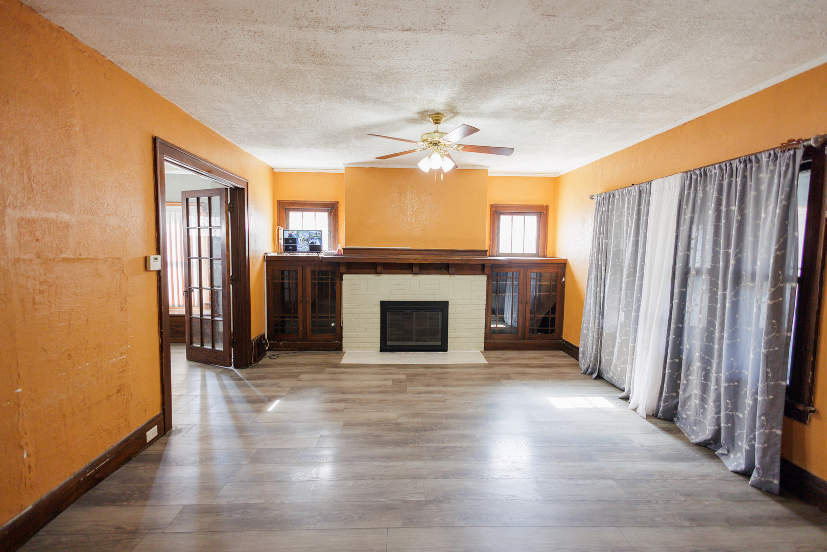 378 South Evergreen Avenue Kankakee, IL 60901 - Photo 10 of 26 an empty room with wooden floor a fireplace and entryway