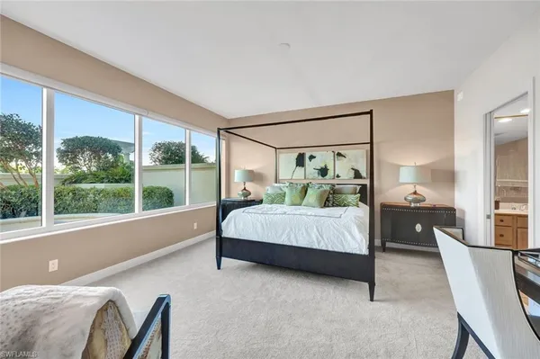 a bedroom with a bed and large window