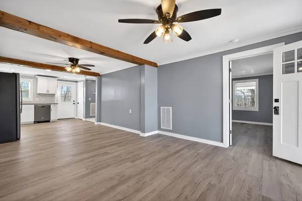 a view of empty room with wooden floor and ceiling fan