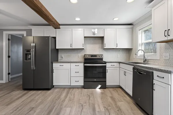 a kitchen with stainless steel appliances granite countertop a refrigerator and a stove top oven