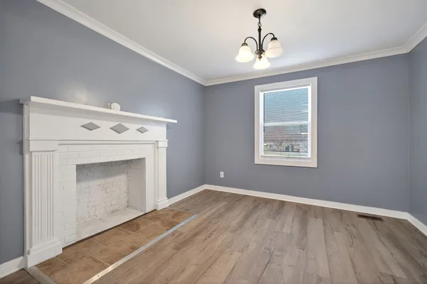 a view of empty room with wooden floor and fireplace