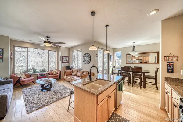 a kitchen with stainless steel appliances granite countertop a stove and a view of living room