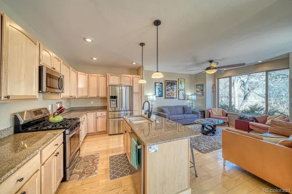 a kitchen with stainless steel appliances granite countertop a sink stove and refrigerator