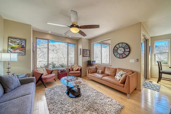 a living room with furniture a clock on wall and a window