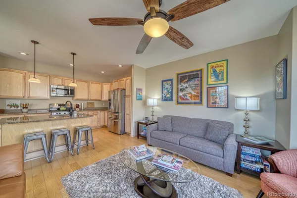 a living room with furniture kitchen view and a chandelier