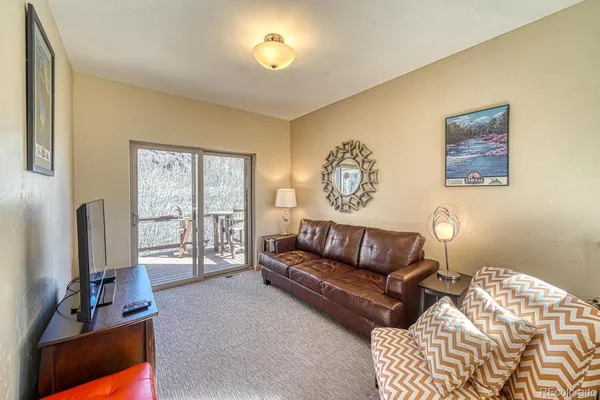 a living room with furniture flat screen tv and a large window