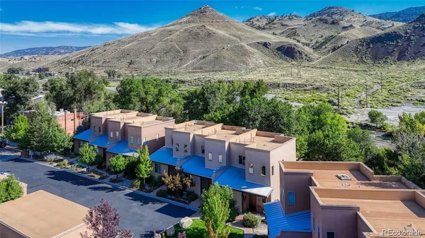 an aerial view of a house with a yard and mountain view in back