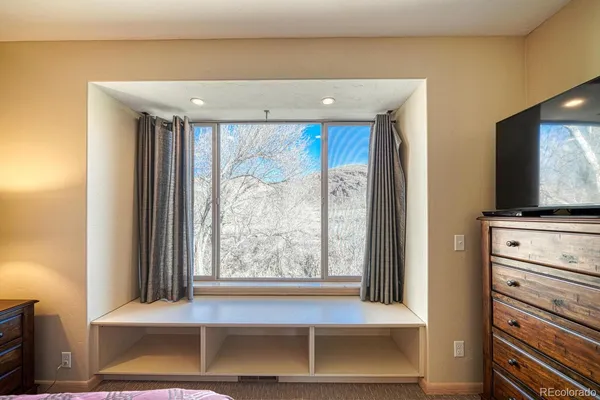 a living room with a bed furniture and a flat tv screen