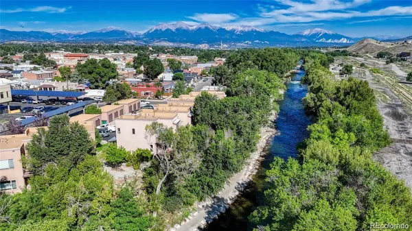 an aerial view of residential houses with outdoor space and trees