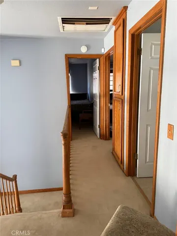 a view of a hallway with wooden shelves and door