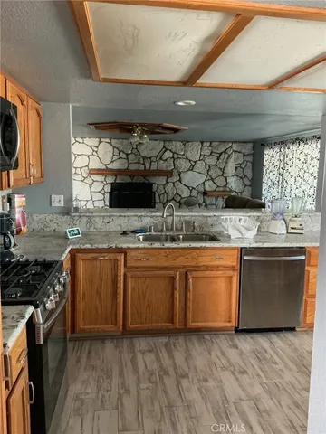 a kitchen with stainless steel appliances granite countertop wooden cabinets and a stove top oven