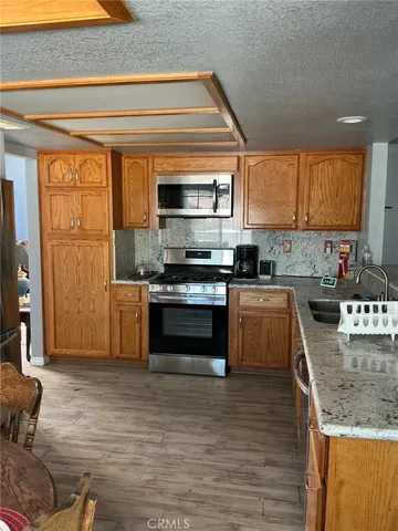 a kitchen with stainless steel appliances granite countertop a stove a sink and a microwave