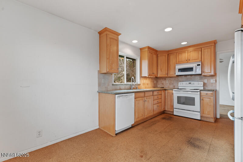 1606 Knoll Drive Reno, NV 89509 - Photo 14 of 30 a kitchen with white cabinets and white appliances
