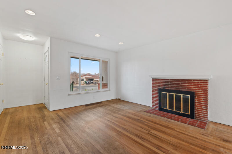 1606 Knoll Drive Reno, NV 89509 - Photo 9 of 30 a view of an empty room with wooden floor fireplace and a window