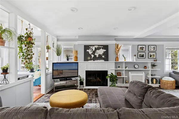 a living room with furniture a flat screen tv and a fireplace