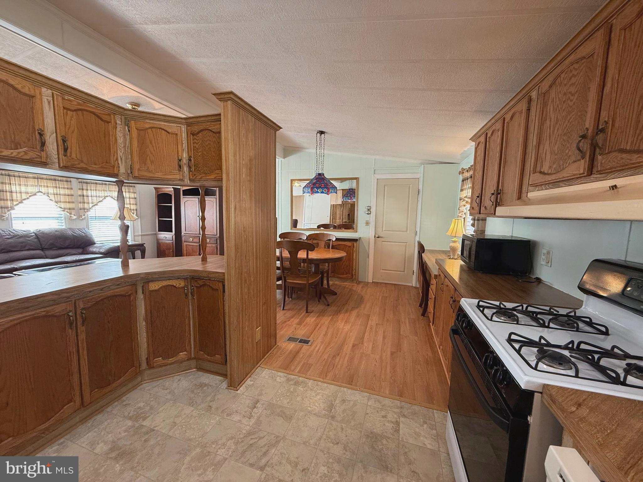 386 Indian Way Buena, NJ 08310 - Photo 9 of 53 a kitchen with stainless steel appliances granite countertop a stove refrigerator and a view of living room