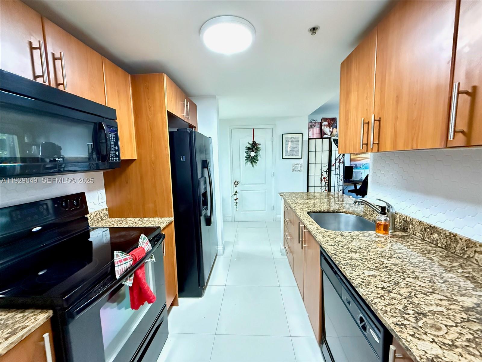 2701 Southwest 3rd Avenue, Unit 202 Miami, FL 33129 - Photo 15 of 32 a kitchen with stainless steel appliances granite countertop a sink stove and refrigerator