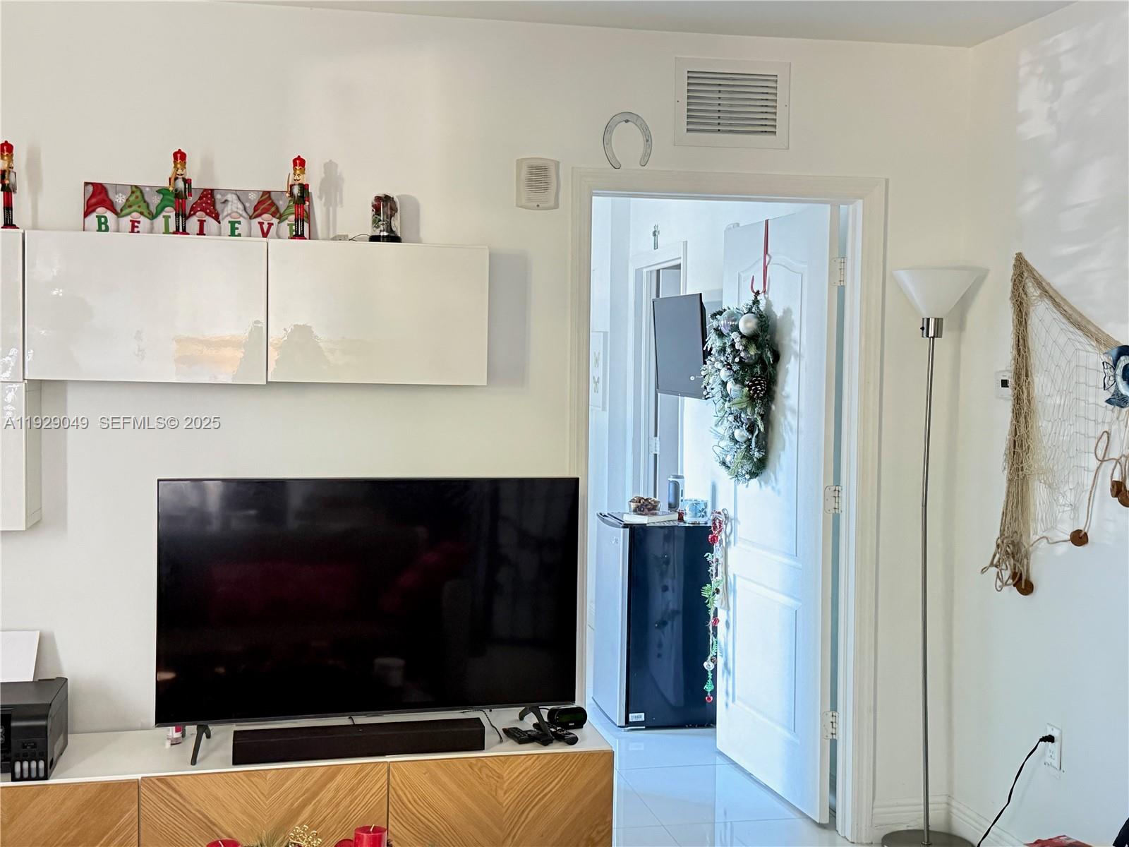 2701 Southwest 3rd Avenue, Unit 202 Miami, FL 33129 - Photo 18 of 32 a living room with a fireplace and a flat screen tv