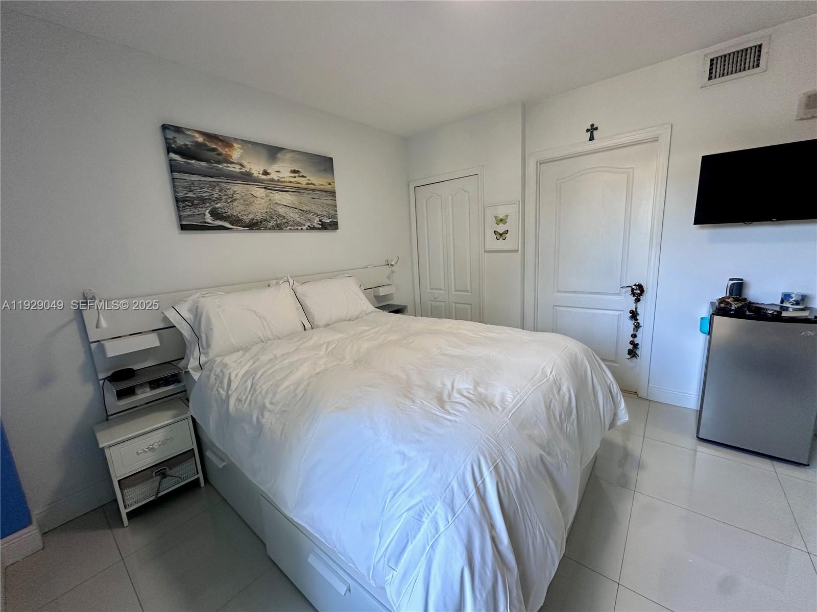 2701 Southwest 3rd Avenue, Unit 202 Miami, FL 33129 - Photo 21 of 32 a bedroom with a bed and a flat screen tv