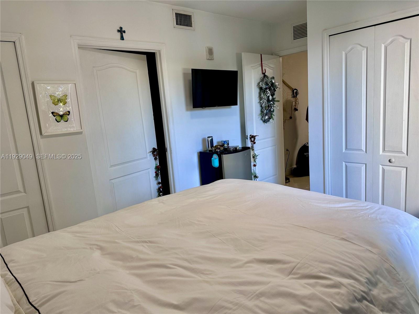 2701 Southwest 3rd Avenue, Unit 202 Miami, FL 33129 - Photo 22 of 32 a bedroom with a bed and a flat tv screen on the dresser