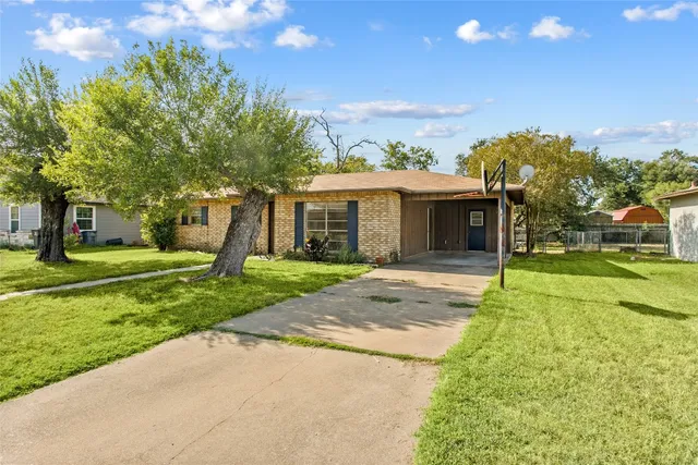 a view of a house with backyard and a tree