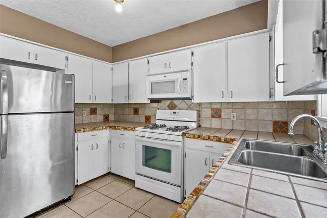 a kitchen with a stove a refrigerator and a sink