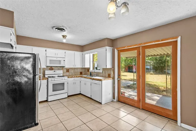 a kitchen with a sink window and stainless steel appliances